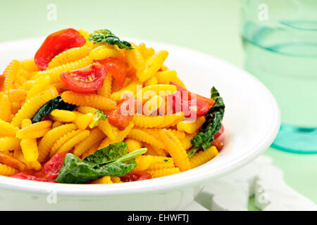 Sardische Teigtaschen, einer traditionellen Nudeln aus Grieß oder Hartweizen Weizen Mehl serviert mit frischen Tomaten und Spinat Stockfoto