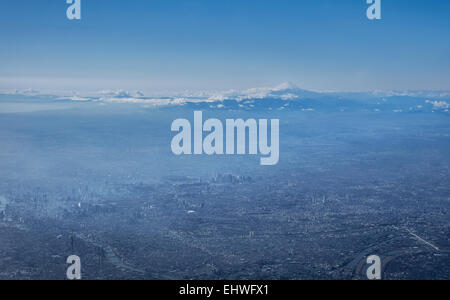 Luftaufnahme der Innenstadt von Tokio an einem sonnigen Tag, mit dem Berg Fuji im Hintergrund. Aufgenommen von einem Verkehrsflugzeug im November 2014 Stockfoto