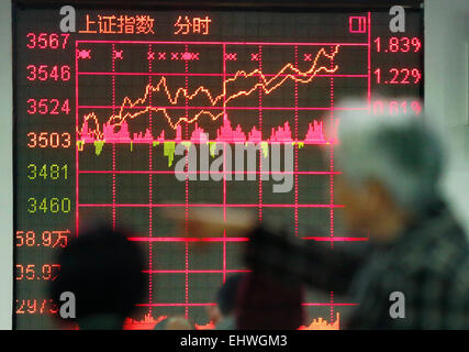 Shanghai, China. 18. März 2015. Investoren suchen durch Bestandsinformationen an einem Handelssaal einer Wertpapierfirma in Shanghai, Ost-China, 18. März 2015. Chinesische Aktien konsolidiert in der Nähe von sieben-Jahres-Hochs am Mittwoch mit der Benchmark Shanghai Composite Index 2,13 Prozent auf 3.577,30 Punkte zu beenden. Der Shenzhen-Komponente-Index stieg von 2,68 Prozent auf 12.496,24 Punkte zu schließen. Bildnachweis: Ding Ting/Xinhua/Alamy Live-Nachrichten Stockfoto