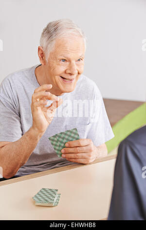Zwei glückliche senior Männer Spielkarten zusammen in einem Pflegeheim Stockfoto