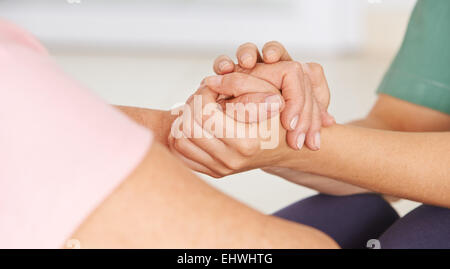 Geriatrische Krankenschwester Hand in Hand senior Frau für Trost Stockfoto