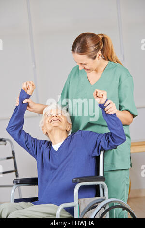 Alte Frau macht Physiotherapie im Pflegeheim mit geriatrischen Krankenschwester Stockfoto