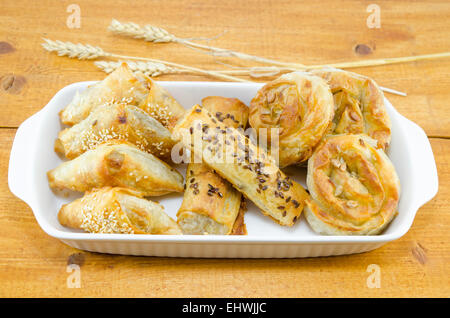 Teller voll mit verschiedenen Arten von Kuchen auf einem Holztisch verziert mit Weizen-sticks Stockfoto