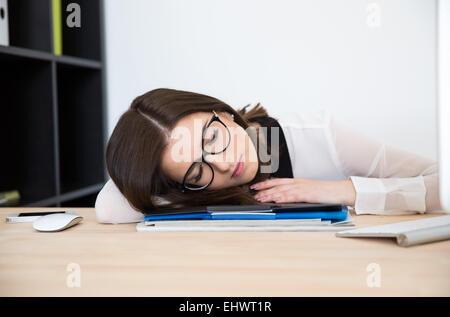 Schöne Geschäftsfrau schlafen am Tisch im Büro Stockfoto