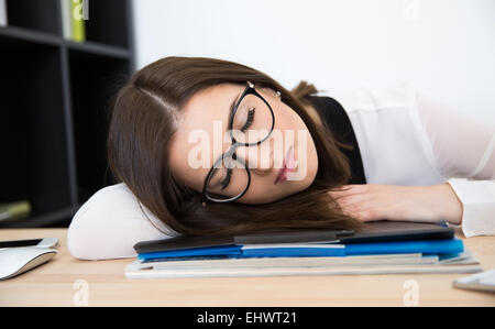 Junge Geschäftsfrau schlafen am Tisch im Büro Stockfoto