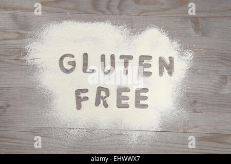 Wort glutenfrei in weißes Mehl auf einem alten Holztisch, Vintage-Ton geschrieben. Stockfoto