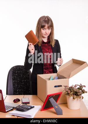 Frau von ihrem Job im Büro gefeuert und sammeln Sie persönliche Gegenstände in einer Kiste mit einem traurigen Blick Stockfoto