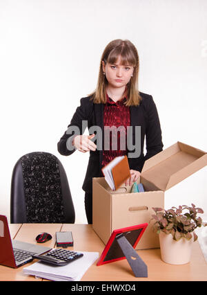 Frau von ihrem Job im Büro gefeuert und sammeln Sie persönliche Gegenstände in einer Kiste mit einem traurigen Blick Stockfoto