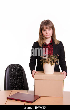 Frau gefeuert aus ihrem Job im Büro, auf der Suche leider in den Rahmen mit einer Box und eine eingemachte Blume in der hand Stockfoto