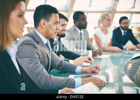 Business-Leute sitzen im Konferenzsaal Stockfoto