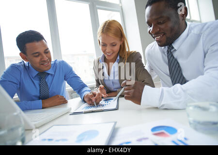 Drei Geschäftsleute über Finanzbericht Stockfoto