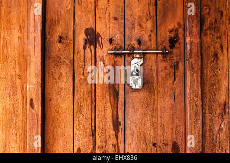 Eine geschlossene braune Holztür aus einem ländlichen Ort in Indien. Stockfoto