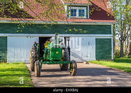 Vintage John Deere Traktor vor einer alten Scheune. Stockfoto