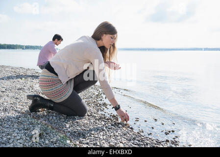 Junges Paar Seeufer sammeln Kieselsteine Stockfoto