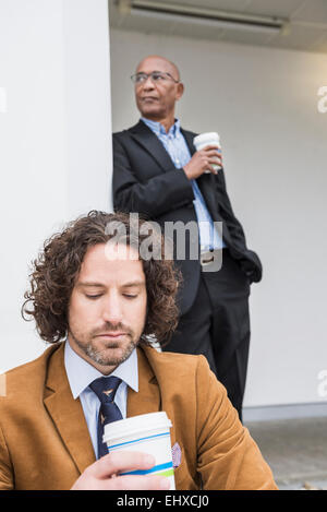 Zwei Geschäftsleute afrikanischen kaukasischen Kaffee zum mitnehmen Stockfoto