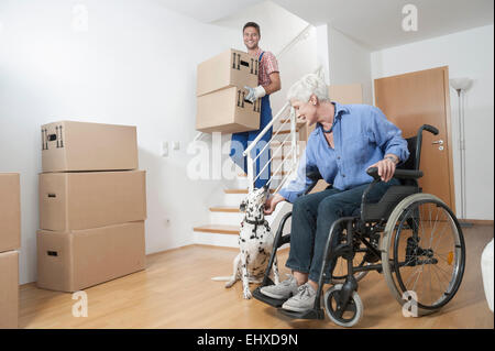 Behinderte alte Frau streicheln Hund während Aufsteiger hinunter Kartons, Bayern, Deutschland Stockfoto