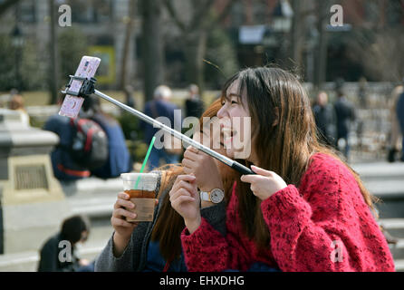 Zwei asiatische lachende Frauen, die ein Selbstporträt in der Nähe von dem Brunnen im Washington Square Park in Greenwich Village, New York City Stockfoto