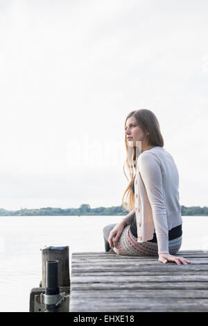 Porträt junge Frau sitzen Steg nachdenklich Stockfoto