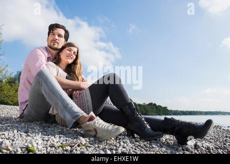 Paar-Sitzung Seeufer glücklich umarmt Stockfoto