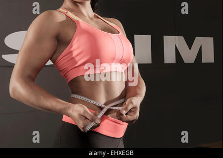 Nahaufnahme Detail muskulöse Frau messen Taille Stockfoto