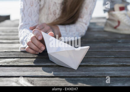 Frau mit Papier Boot Holzsteg hautnah Stockfoto