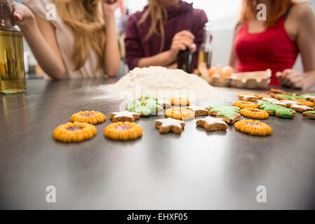 Freunde, die am weihnachtsabend zu Hause Kekse backen, München, Bayern, Deutschland Stockfoto