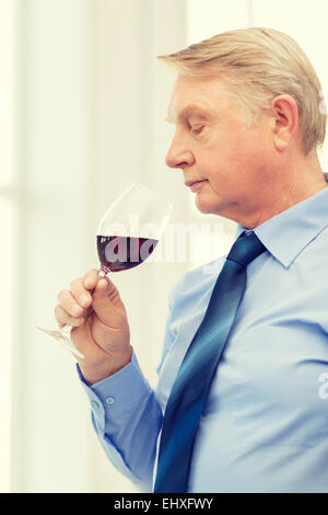 älterer Mann riechen Rotwein Stockfoto