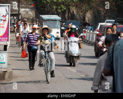 Menschen, die Reiten Fahrräder und Motorroller auf den Straßen von Yangshuo, China Stockfoto