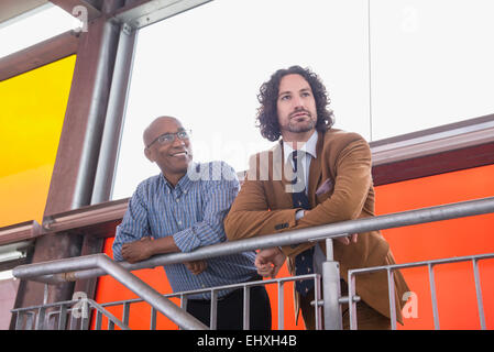 Zwei Männer treffen sprechen afrikanischen kaukasischen Geländer Stockfoto
