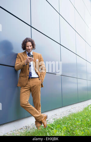 Portrait Mann Business Anzug Handy SMS lesen Stockfoto