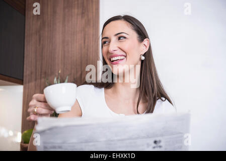 Frau, trinken eine Tasse Kaffee und liest eine Zeitung, München, Bayern, Deutschland Stockfoto