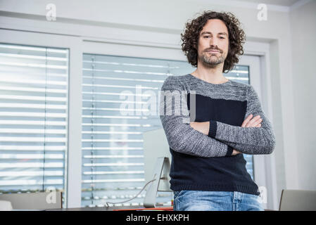 Geschäftsmann steht an einem Tisch in einem Büro, München, Bayern, Deutschland Stockfoto