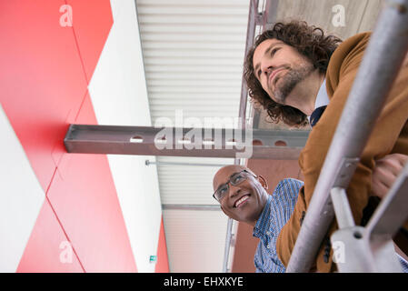 Zwei Männer treffen sprechen afrikanischen kaukasischen Geländer Stockfoto