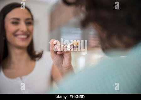 Frau, Fütterung Stück Kuchen zu ihrem Mann, München, Bayern, Deutschland Stockfoto