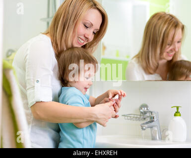 Mutter lehrt Kinder, Hände waschen im Bad Stockfoto
