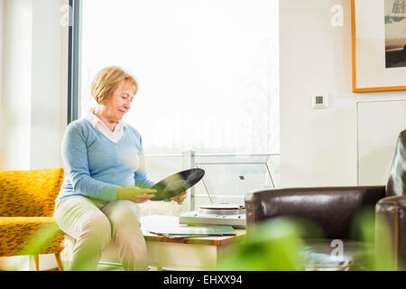 Ältere Frau zu Hause anziehen Plattenspieler record Stockfoto