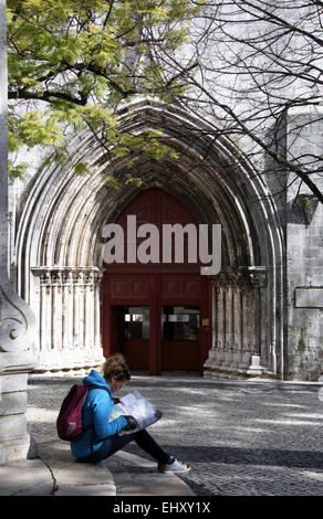 Touristen sitzen vor dem Hauptportal der Gotik Carmo Kirche in Lissabon Stockfoto