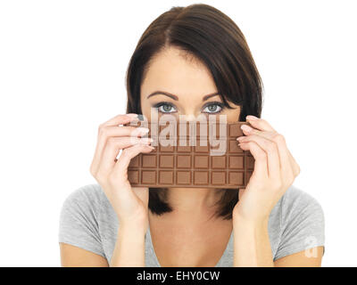 Attraktive junge Frau versteckt sich hinter einem Milch-Schokolade Stockfoto
