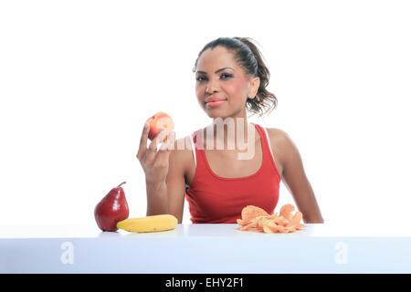 schöne junge Frau, die die Wahl zwischen Obst und Kartoffel-chips Stockfoto