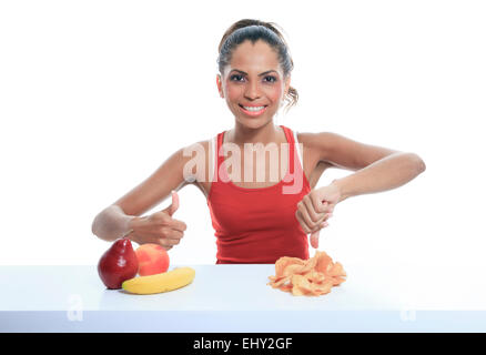 schöne junge Frau, die die Wahl zwischen Obst und Kartoffel-chips Stockfoto