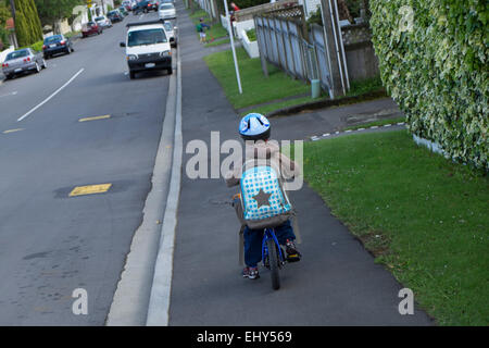 Vier Jahre alter Junge mit Rucksack auf Fahrrad mit Helm zur Schule fahren Stockfoto