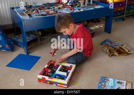 Jungen im Alter von vier Jahren spielen mit Lego-Bausteinen im Schlafzimmer Stockfoto