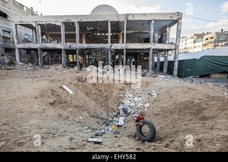 Gaza, Gaza, Palästinensische Gebiete. 1. Oktober 2014. Kind spielt mit einem Reifen in einem Loch eine Bombe in der Nähe der zerstörten Al Susi Moschee in Gaza-Stadt. © Celestino Arce/ZUMA Wire/ZUMAPRESS.com/Alamy Live-Nachrichten Stockfoto