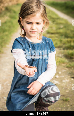 Mädchen halten Wurm in der hand Stockfoto