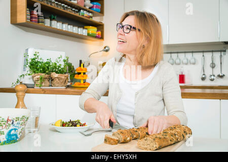 Ältere Frau Schneiden von Brot Stockfoto