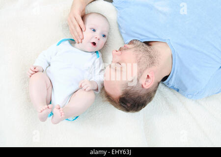 Vater mit Baby entspannend Stockfoto