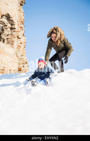 Mutter mit Sohn im Schnee spielen Stockfoto