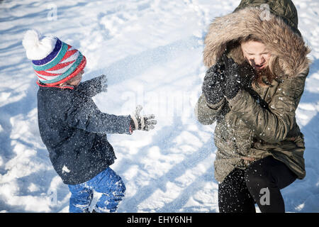 Mutter mit Sohn im Schnee spielen Stockfoto