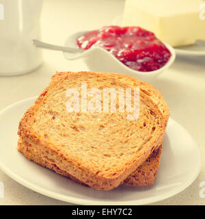 ein gedeckter Tisch mit Teller mit Toast, Marmelade und butter Stockfoto
