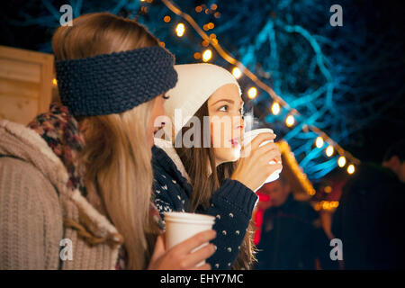 Zwei Frauen trinken Punsch am Weihnachtsmarkt Stockfoto